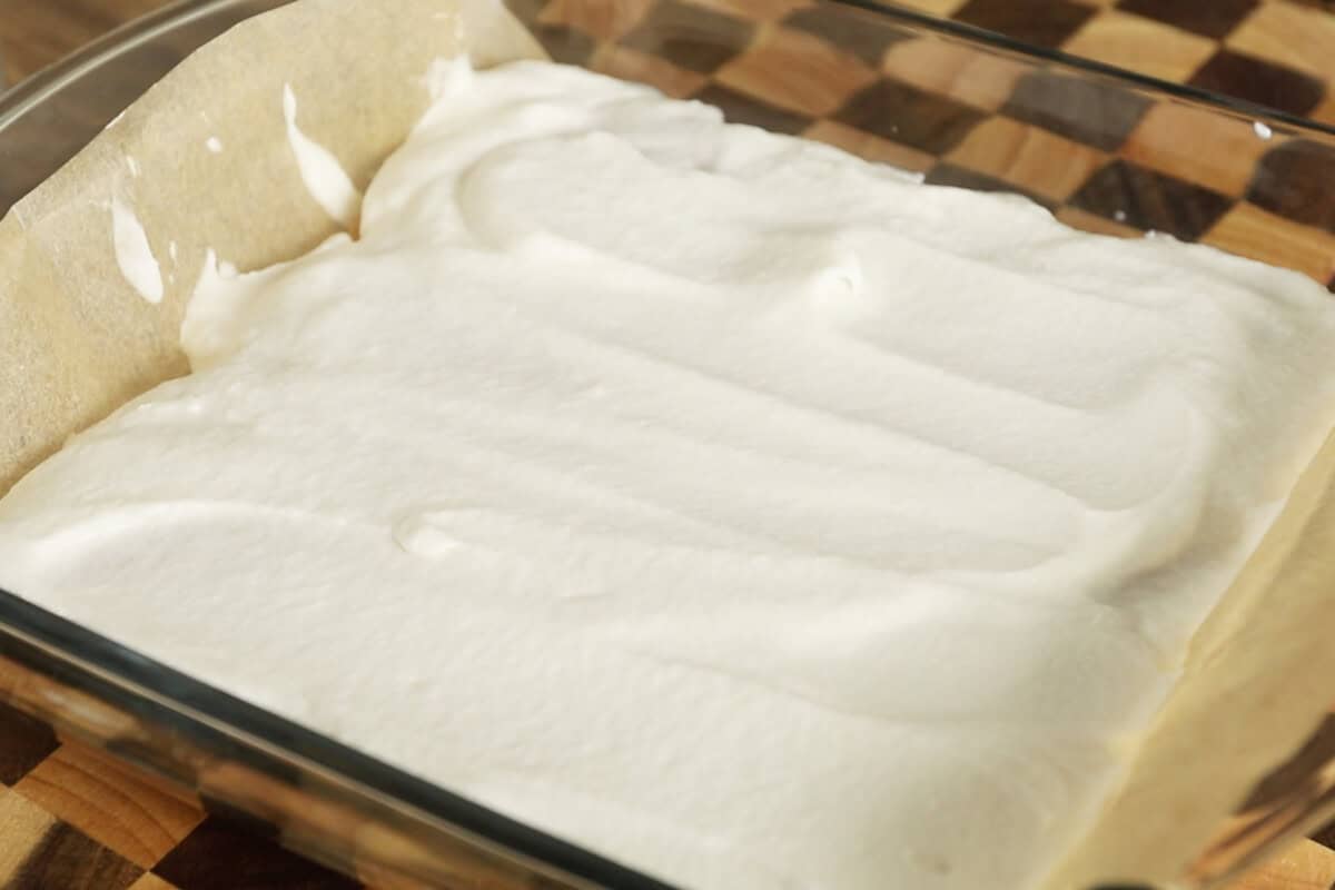 adding whipped heavy cream layer into baking dish