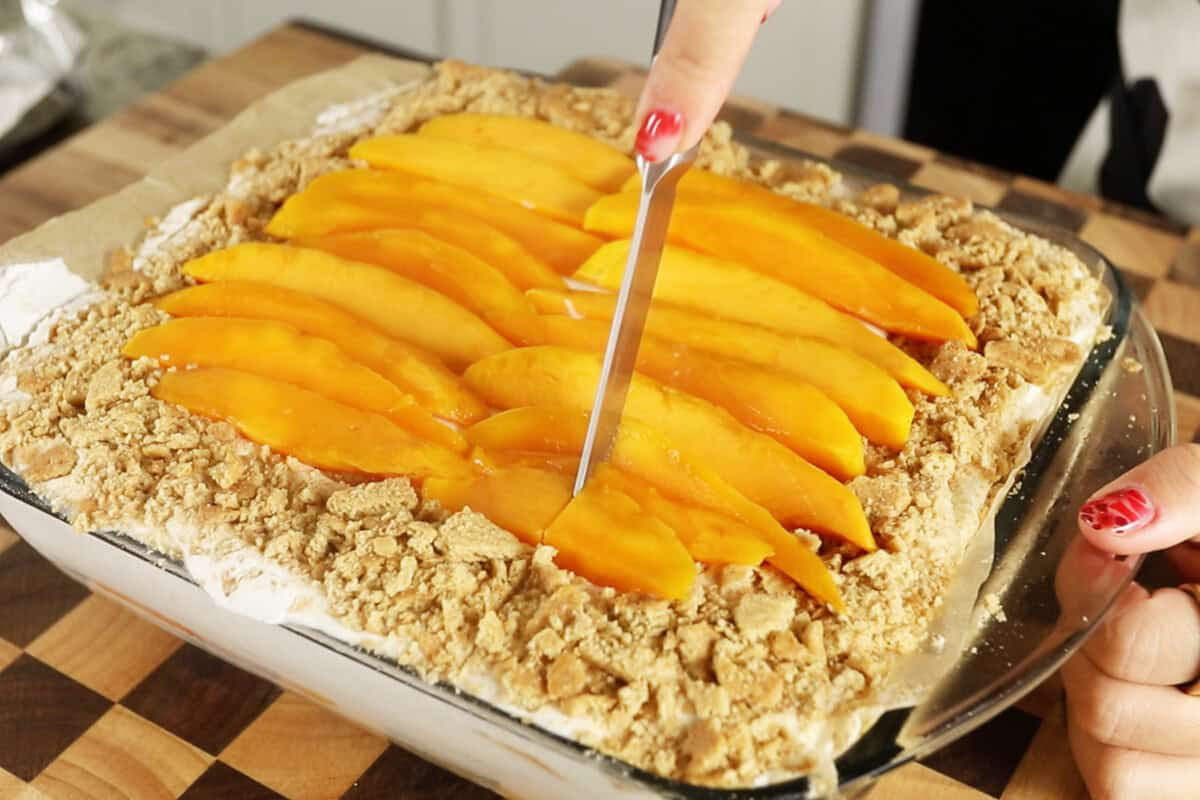 cutting mango float in baking dish