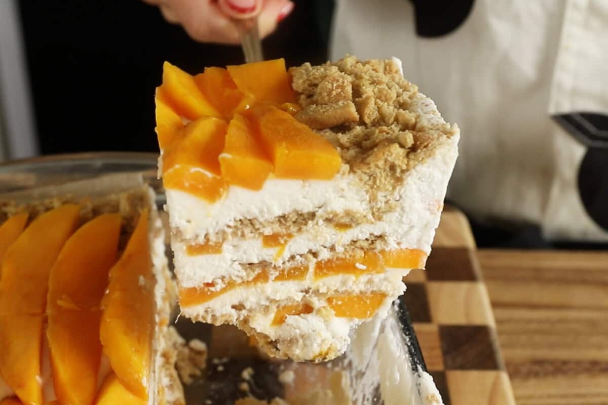 slice of mango float being lifted out of baking dish