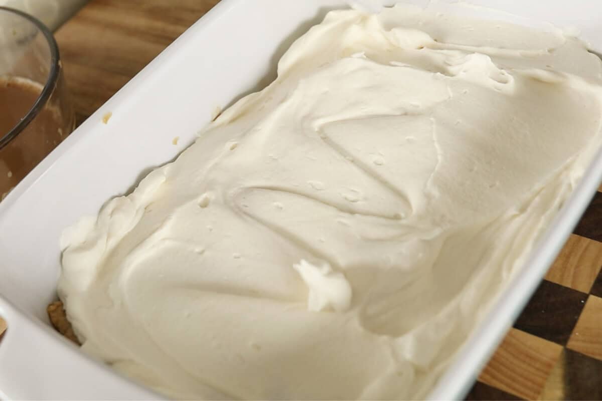 step by step: cream spread over ladyfingers in baking dish