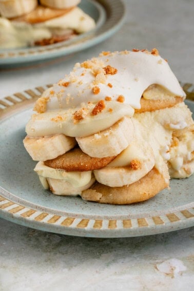 close up of a serving of vegan banana pudding with whipped cream on blue plate