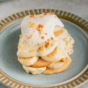 a serving of vegan banana pudding with whipped cream on blue plate