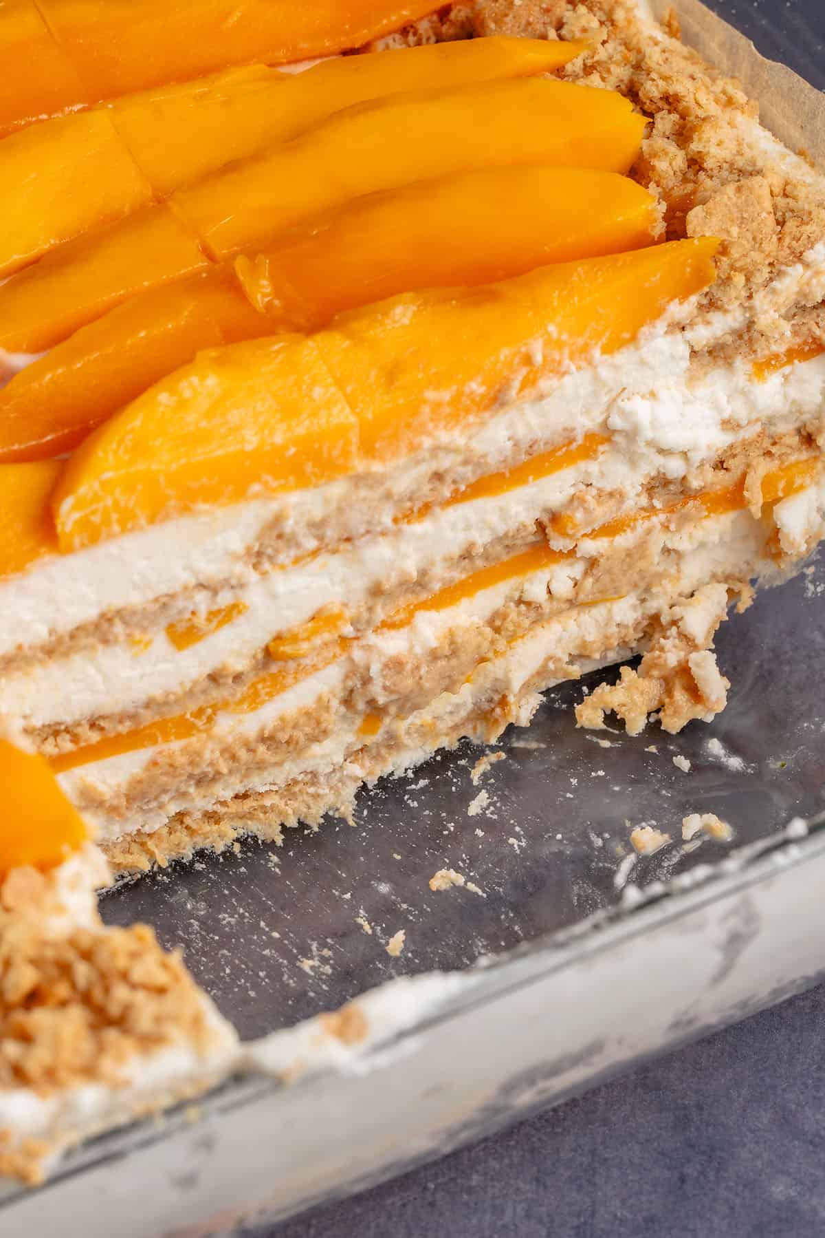 vegan filipino mango float in a baking dish with slices removed