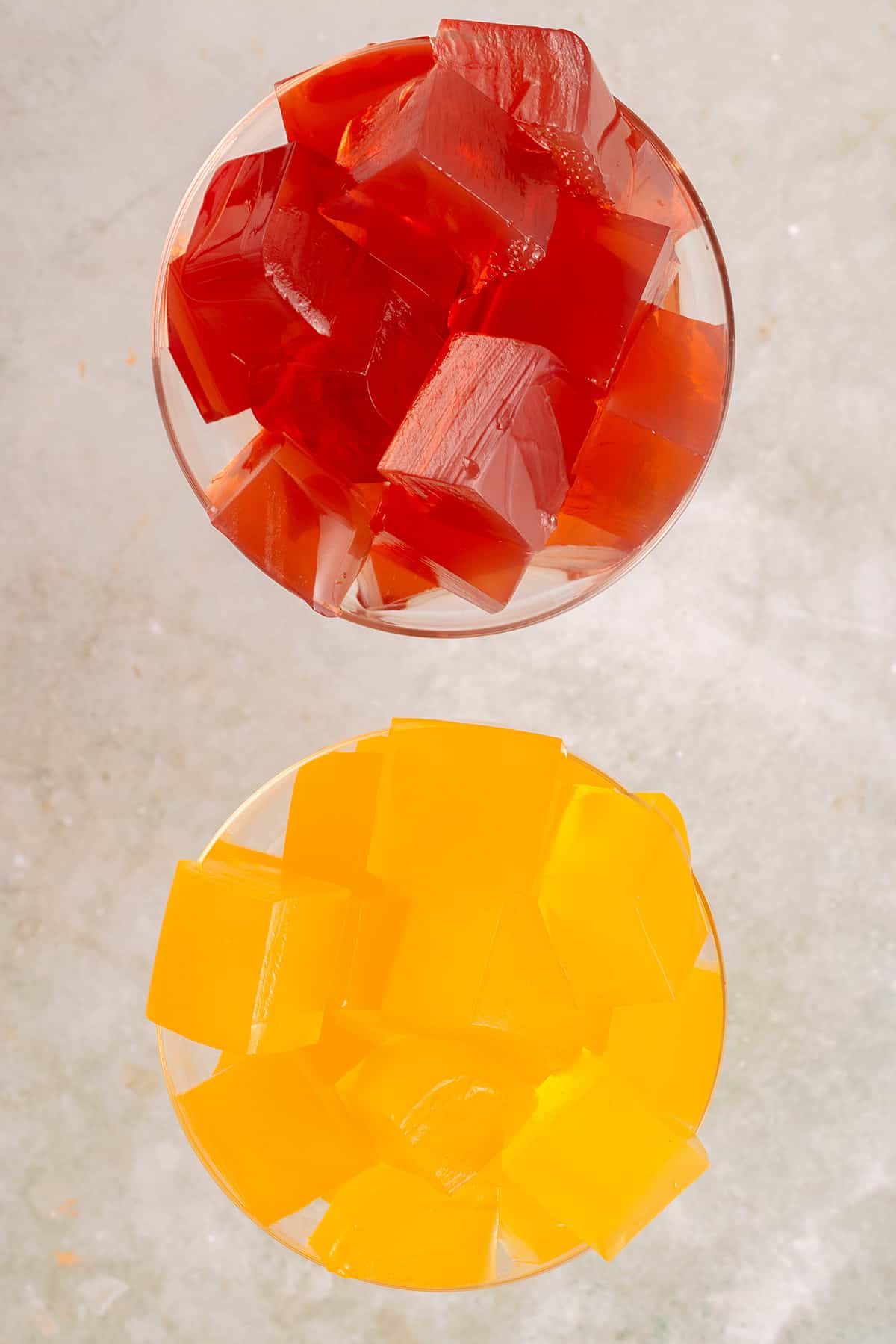 overhead of red and yellow jello cubes in glasses