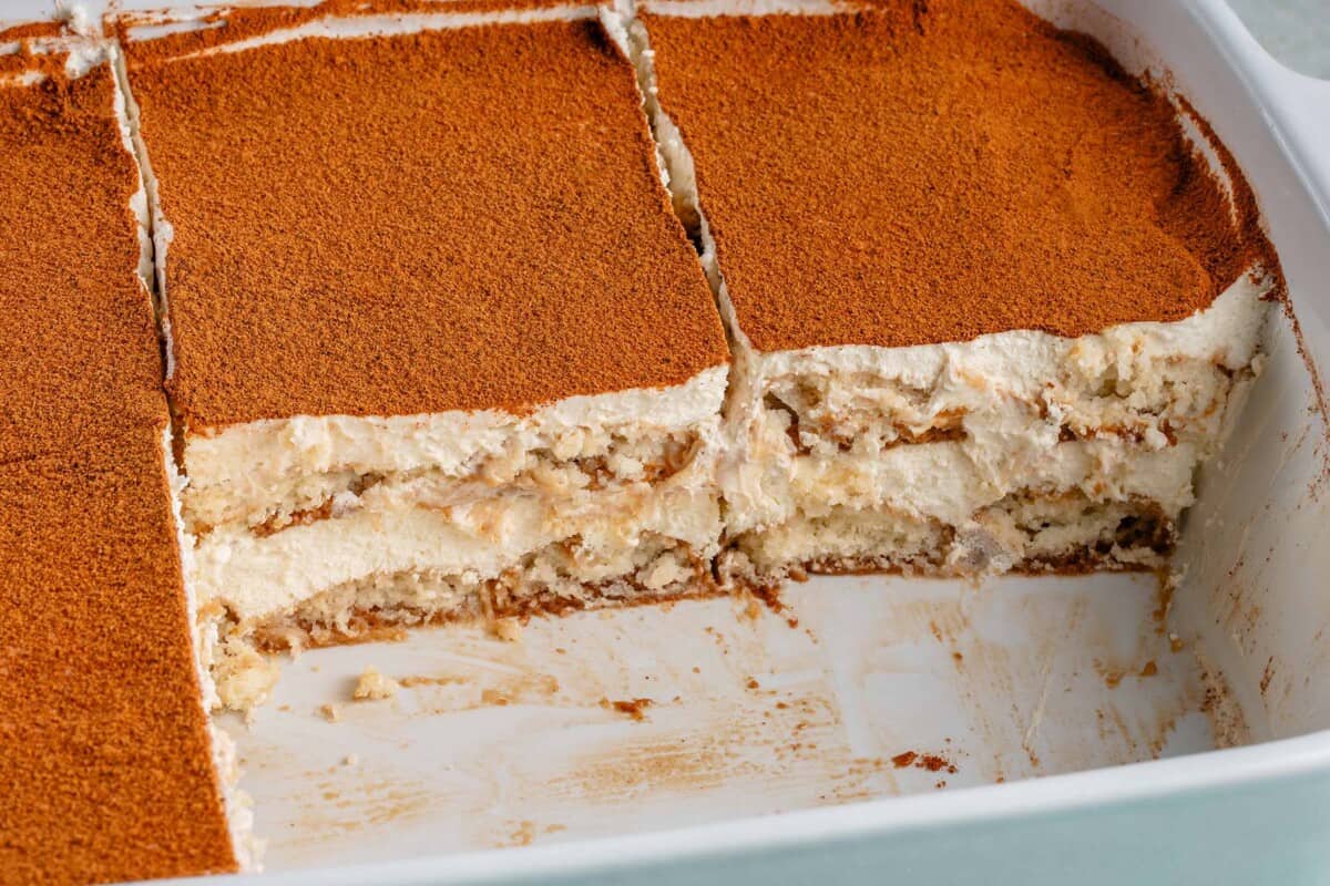 baking dish filled with masala chai tiramisu and two slices missing