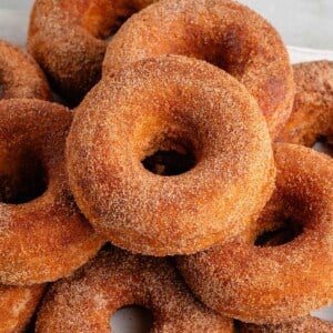 stack of baked apple cider donuts on a white board