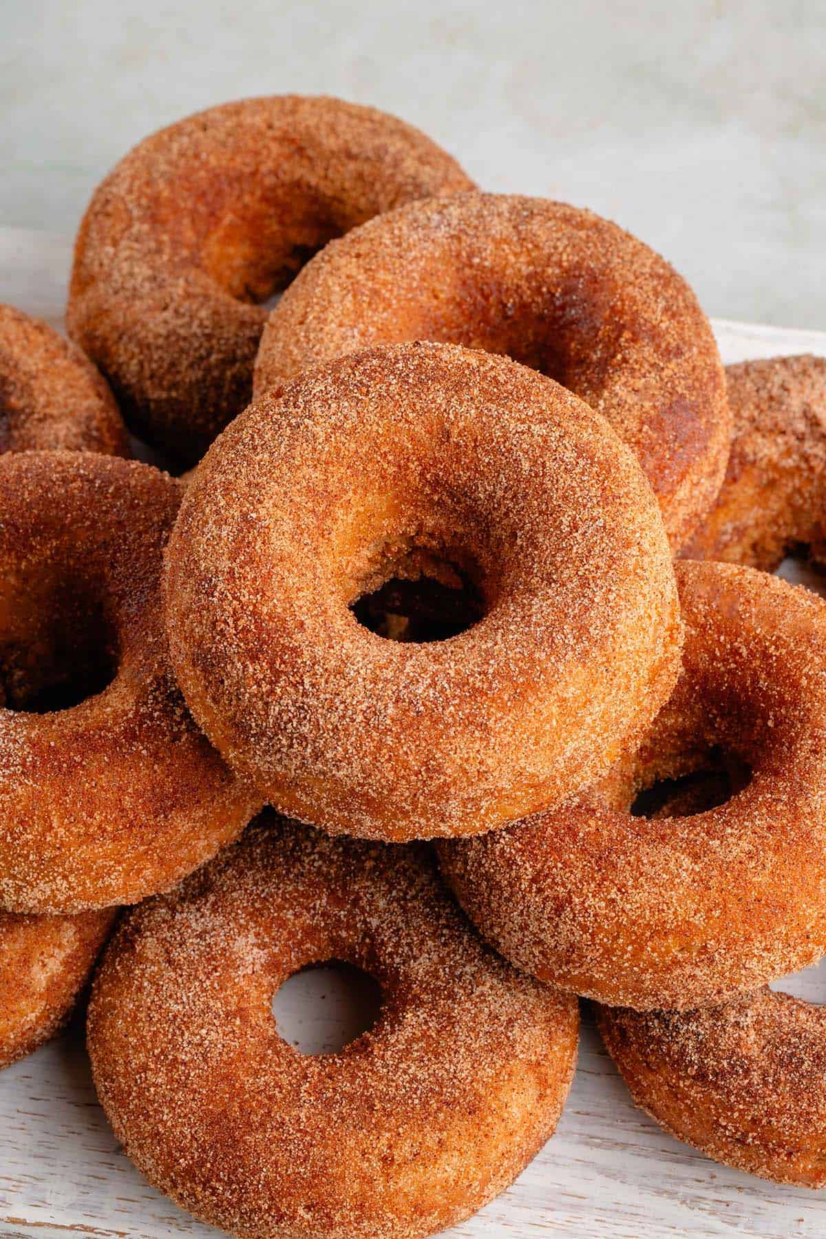 stack of baked apple cider donuts on a white board