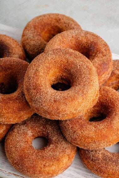 stack of baked apple cider donuts on a white board