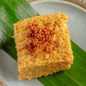 overhead photo of Biko Kalabasa (Pumpkin Biko) on a blue plate with a banana leaf