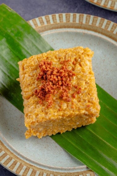 overhead photo of Biko Kalabasa (Pumpkin Biko) on a blue plate with a banana leaf