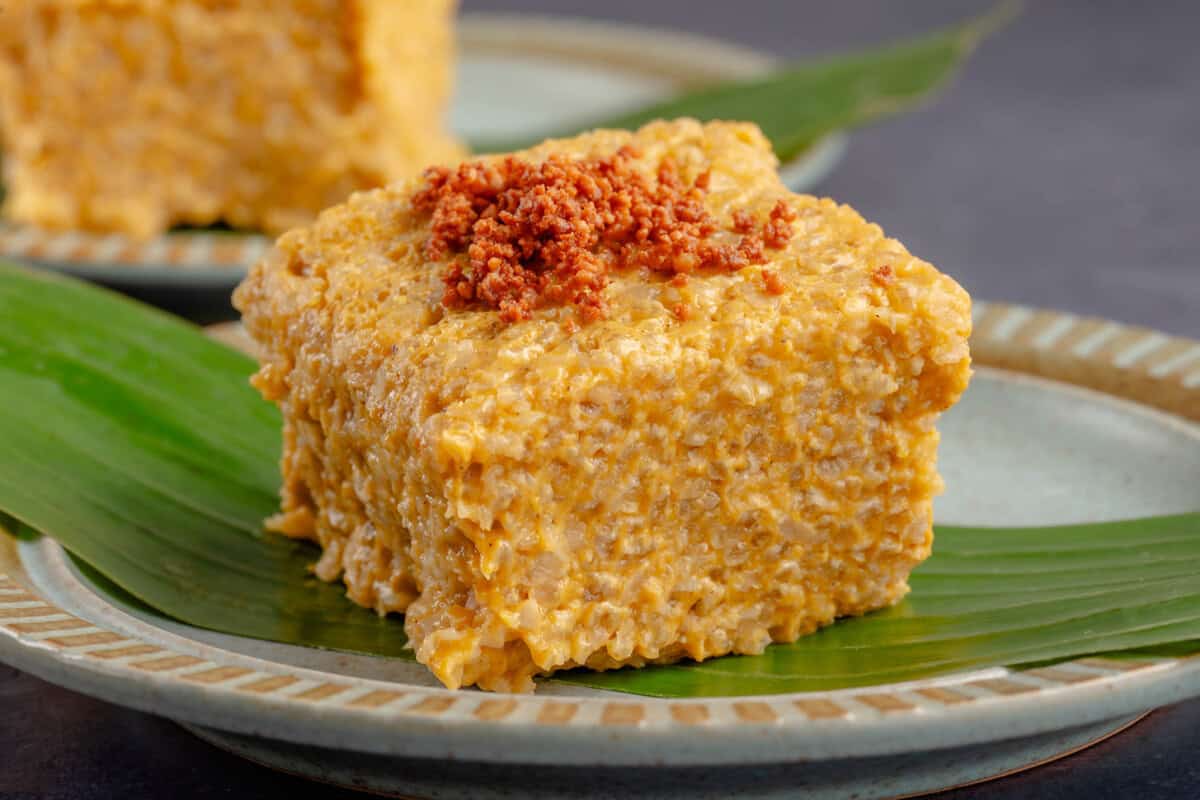 horizontal photo of Biko Kalabasa (Pumpkin Biko) on a blue plate with a banana leaf