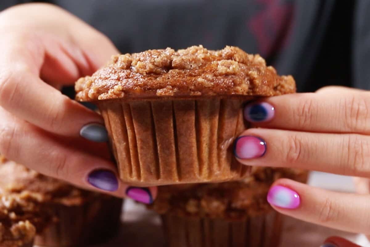 holding a pumpkin cream cheese muffin