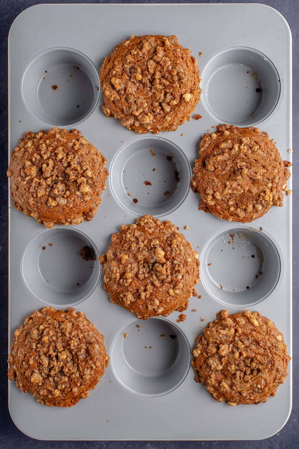 overhead photo of freshly baked pumpkin cream cheese muffins with brown parchment liners