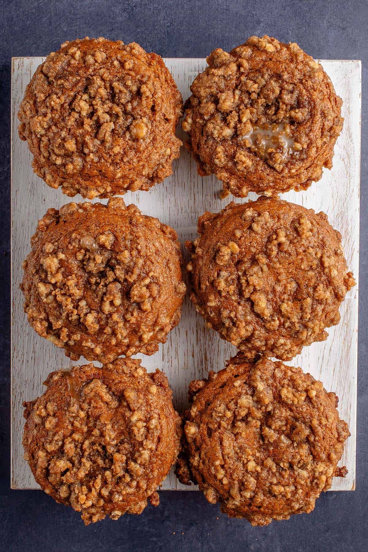 overhead photo of freshly baked pumpkin cream cheese muffins on white board