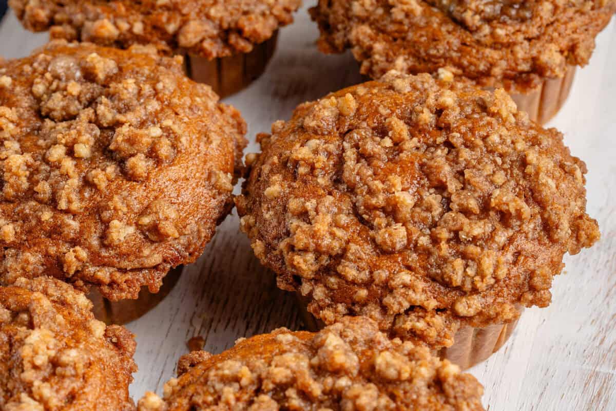 overhead photo of freshly baked pumpkin cream cheese muffins on white board