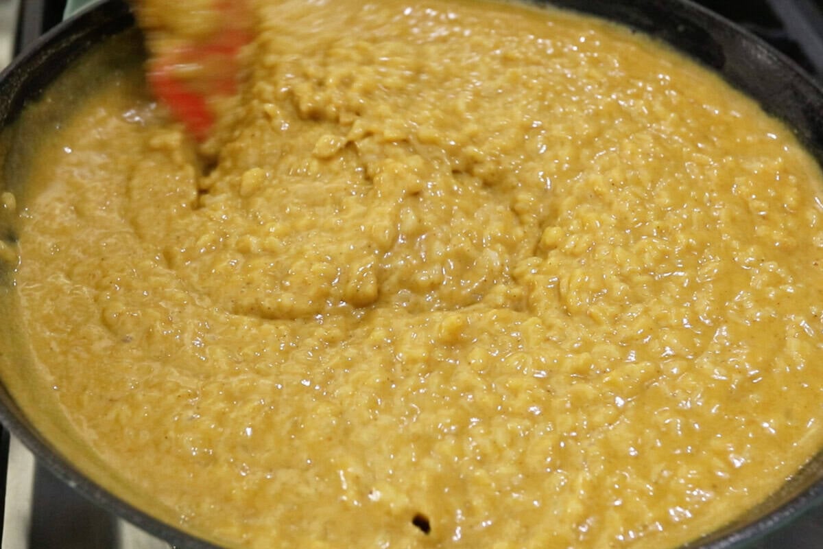 mixing Biko Kalabasa (Pumpkin Biko) in a large wok