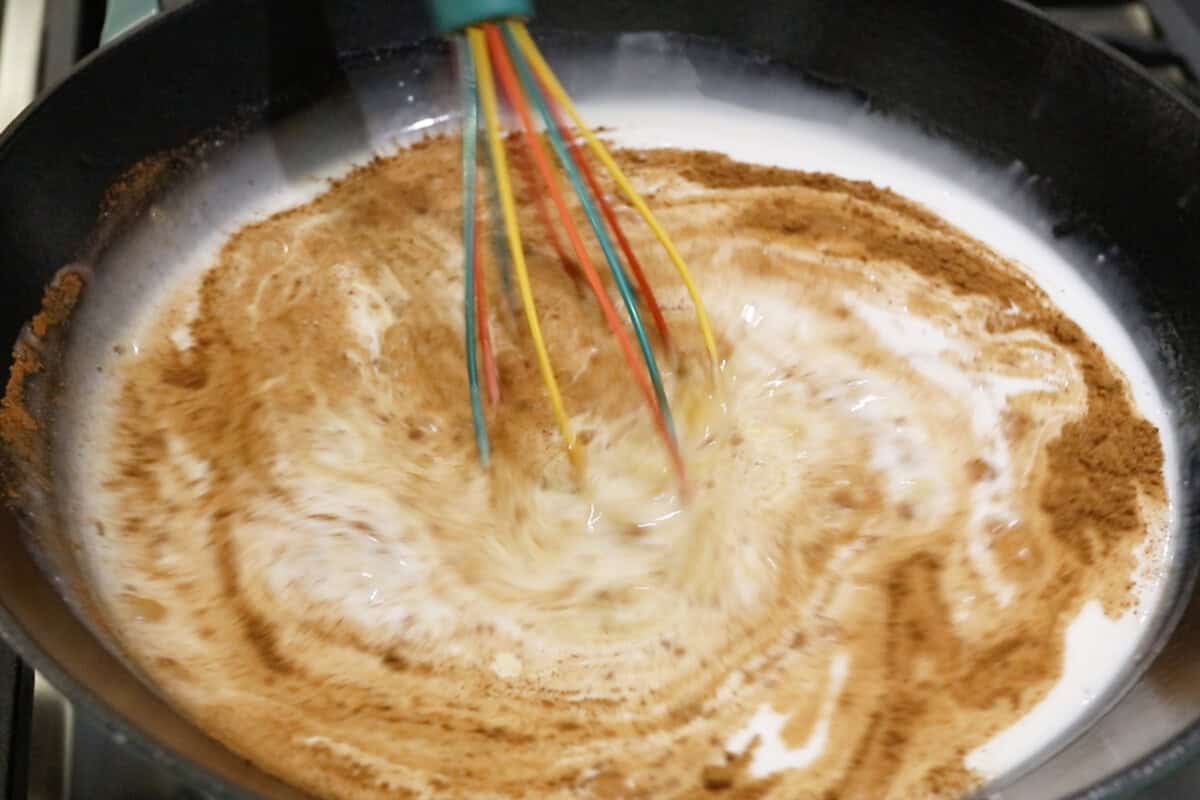 preparing a pumpkin coconut mixture in a wok for Filipino pumpkin biko