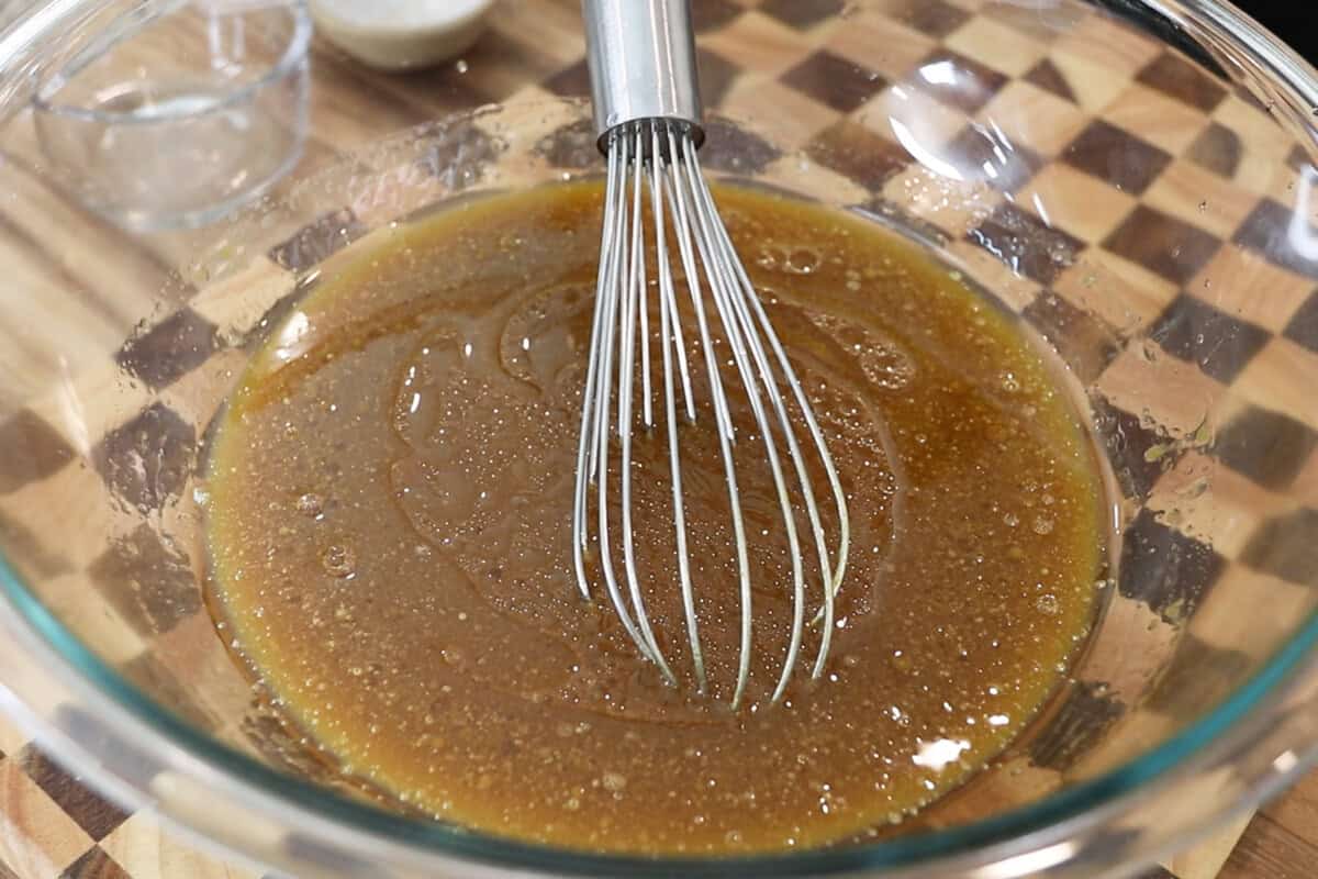 preparing batter for pumpkin cream cheese muffins recipe in large glass bowl