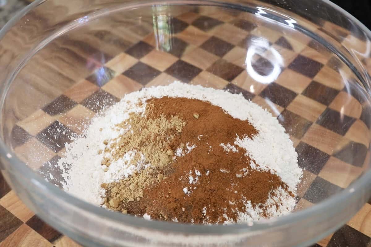 preparing batter for pumpkin cream cheese muffins recipe in large glass bowl