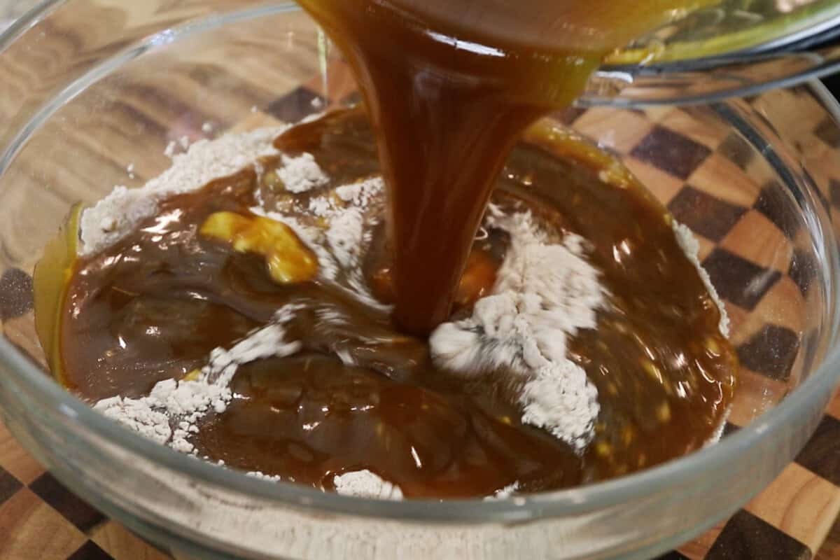 preparing batter for pumpkin cream cheese muffins recipe in large glass bowl