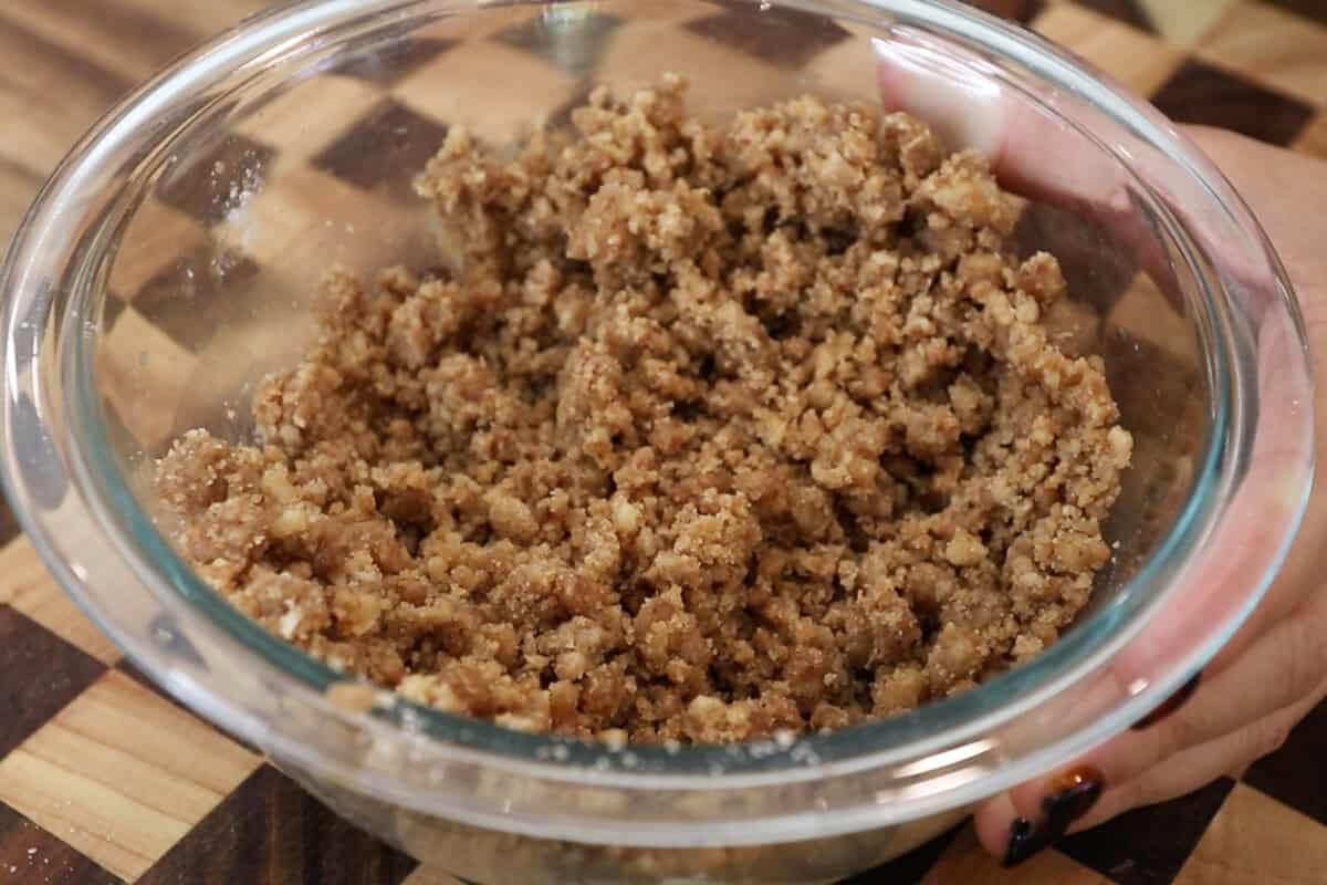 preparing streusel topping in glass bowl for pumpkin cream cheese muffins