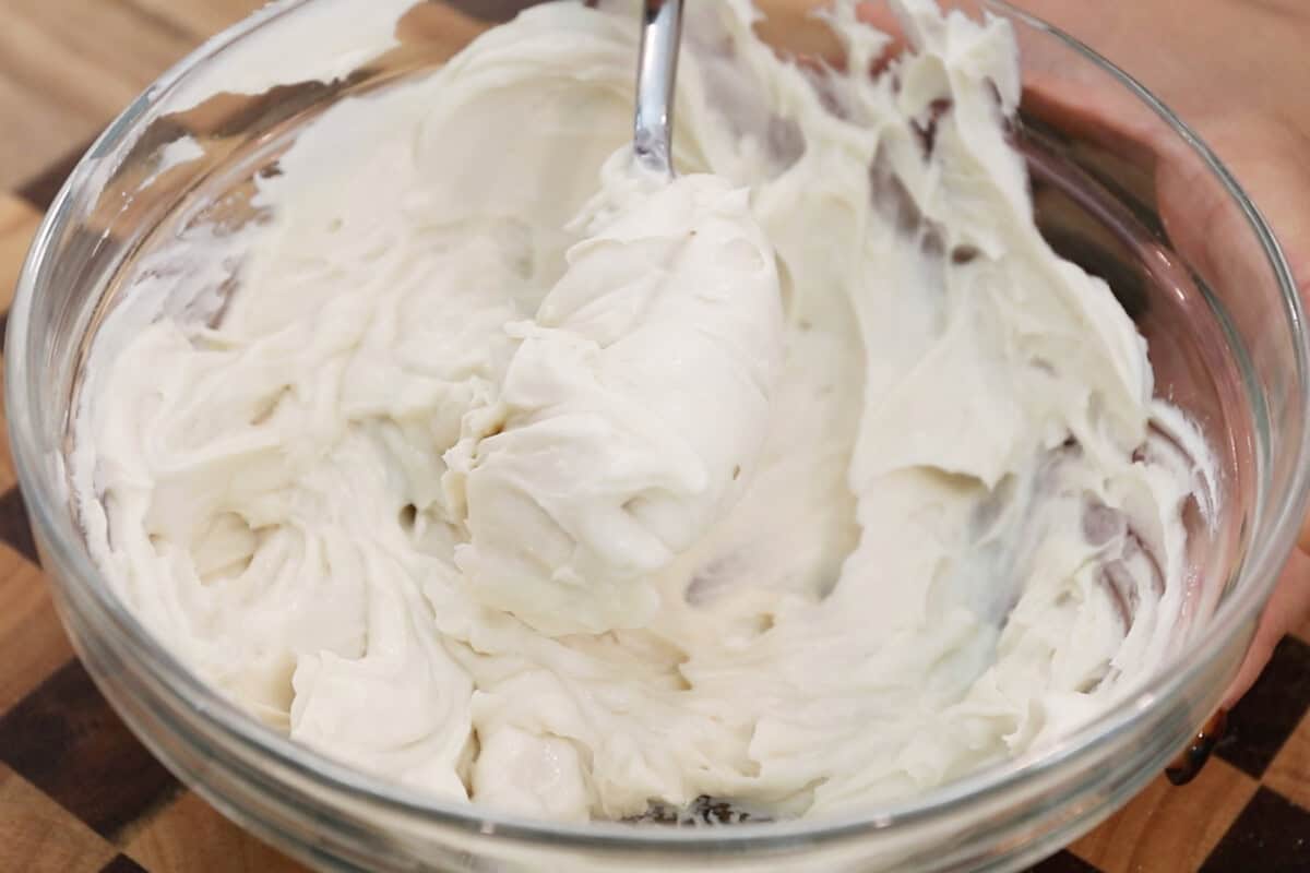 mixture of vegan cream cheese and sugar in glass bowl for pumpkin muffins