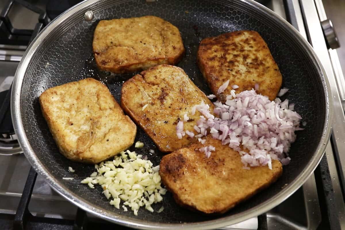 adding shallots and garlic to pan fried tofu