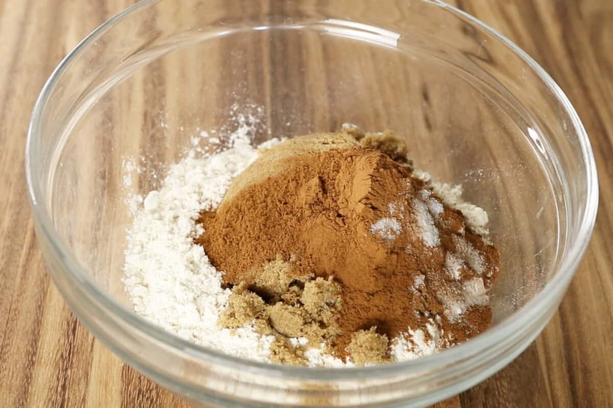 preparing cinnamon streusel topping for vegan coffee cake in glass bowl