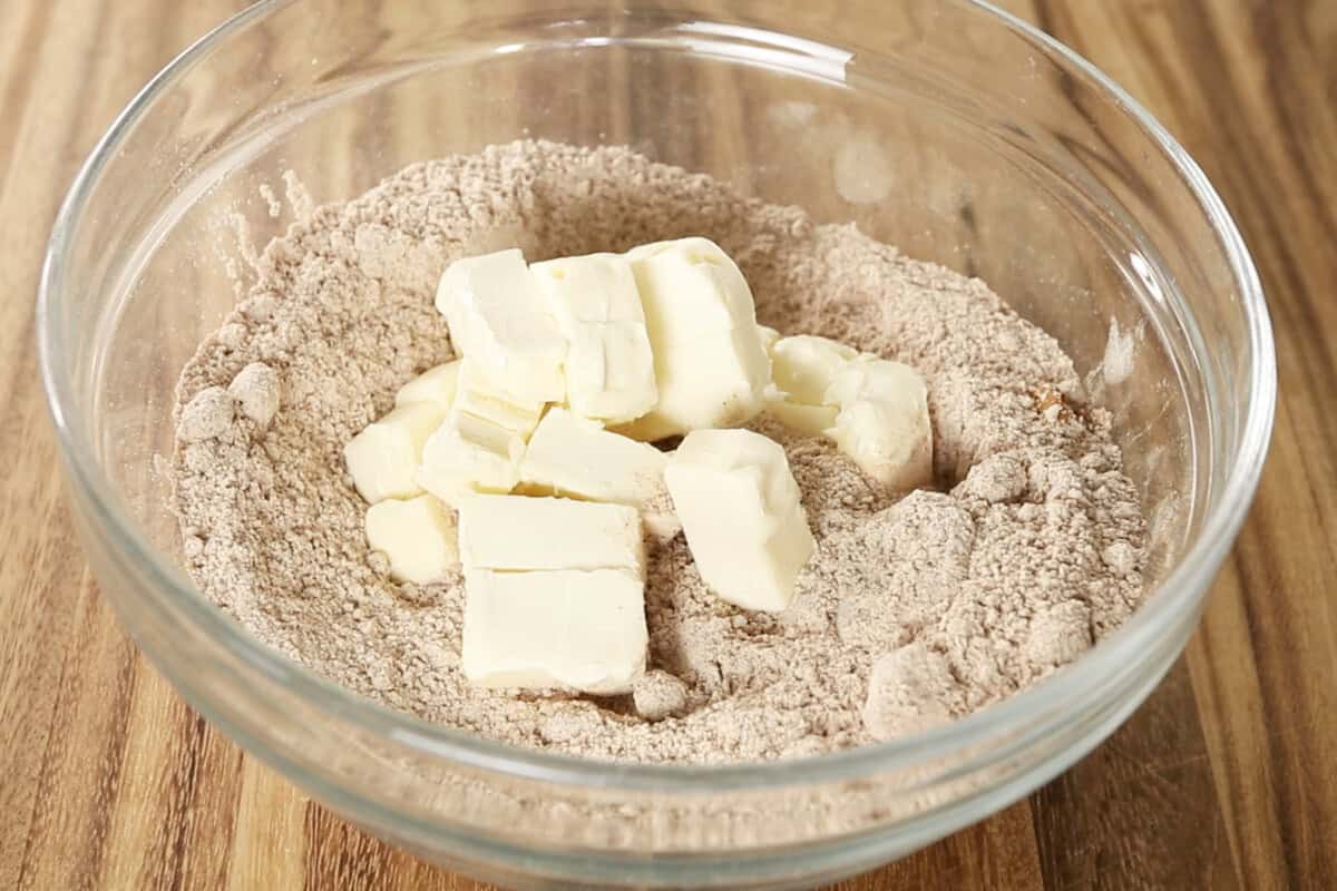 preparing streusel topping for vegan coffee cake in glass bowl