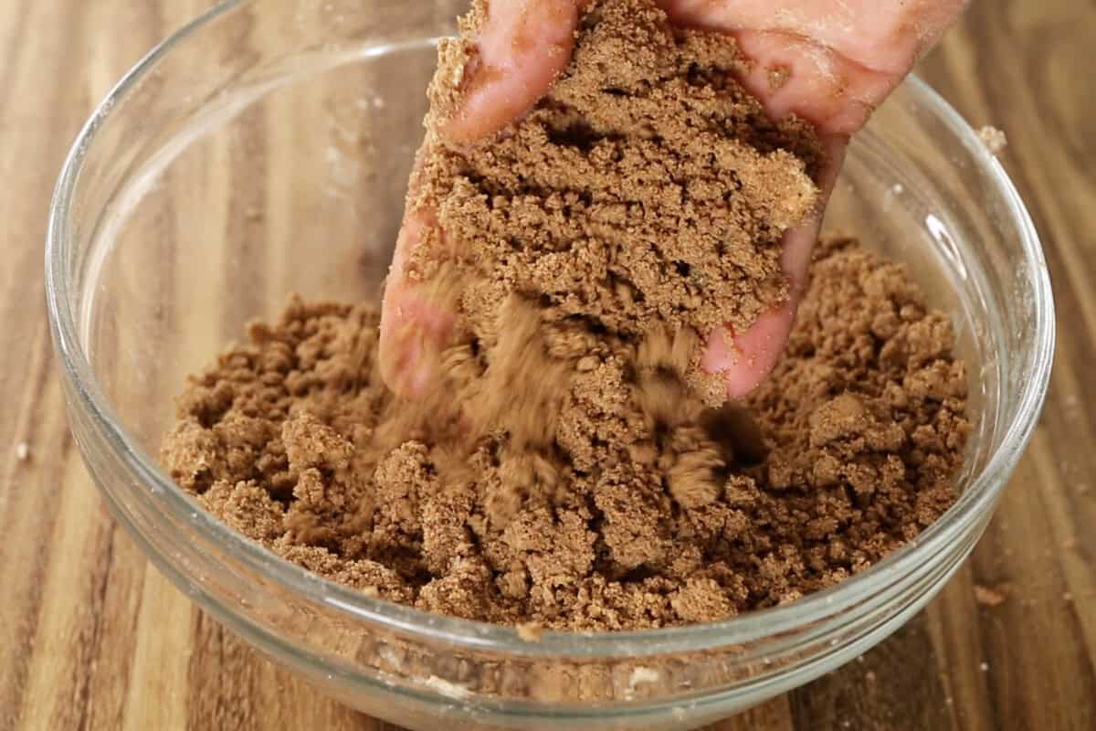 mixing streusel topping for vegan coffee cake in glass bowl