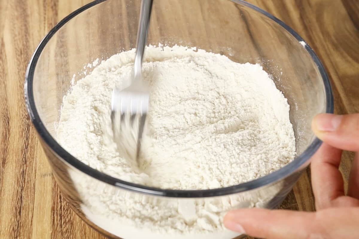 mixing dry ingredients for vegan coffee cake in glass bowl