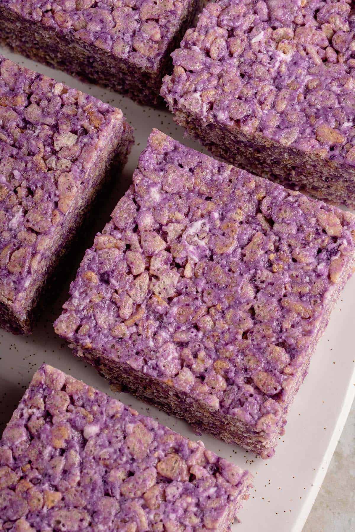 ube rice krispie treats cut into squares onto a white platter