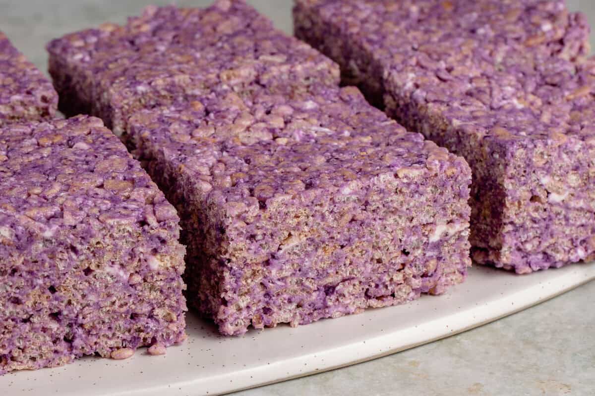 ube rice krispie treats cut into squares onto a white platter