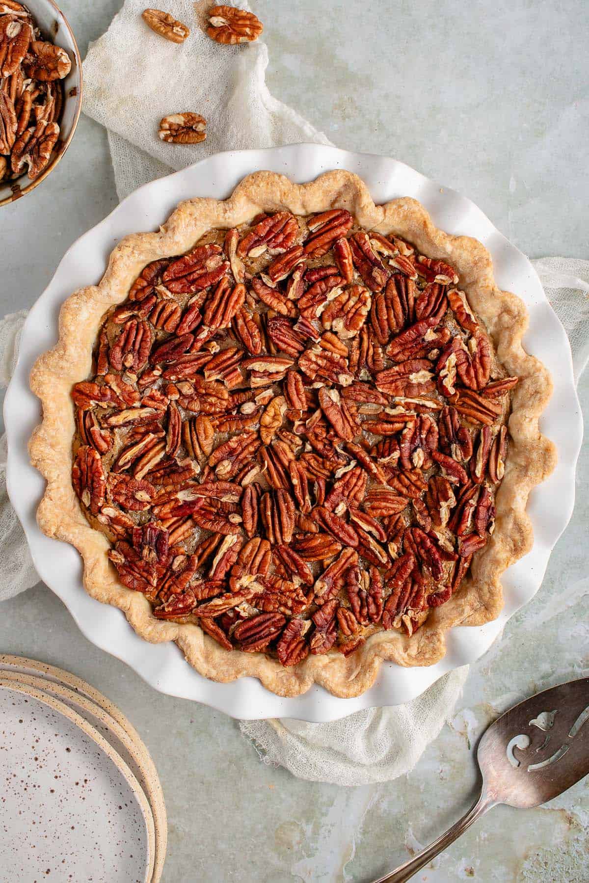 classic vegan pecan pie with a napkin and plates and spatula