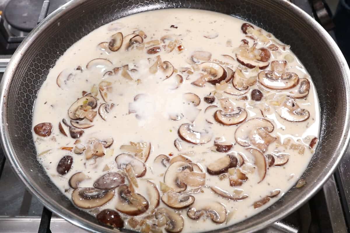 bringing the heavy cream and onion and mushroom mixture to the pan