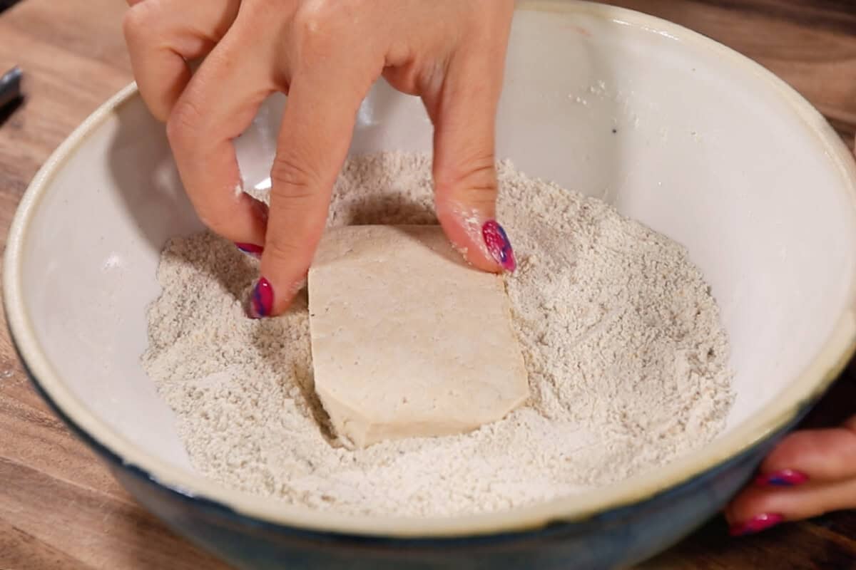 dredging tofu in spice and flour mixture