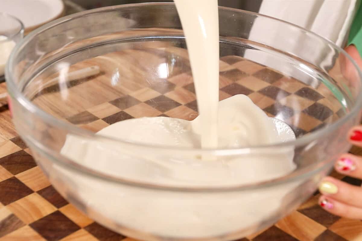 making Filipino Buko Pandan Salad in large glass bowl