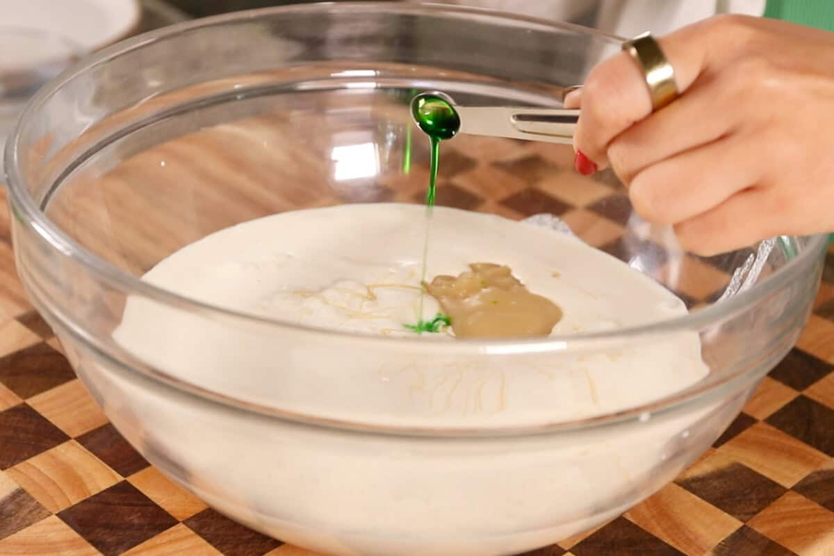 making Filipino Buko Pandan Salad in large glass bowl