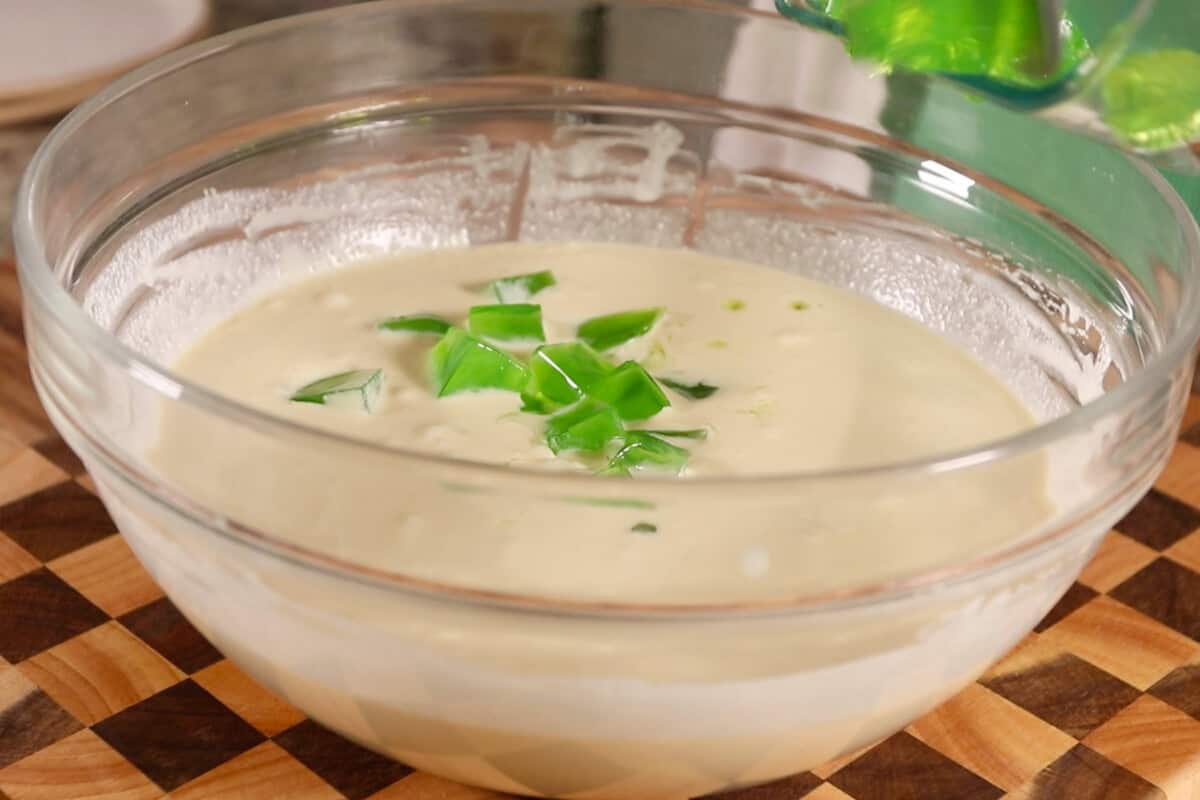 making Filipino Buko Pandan Salad in large glass bowl