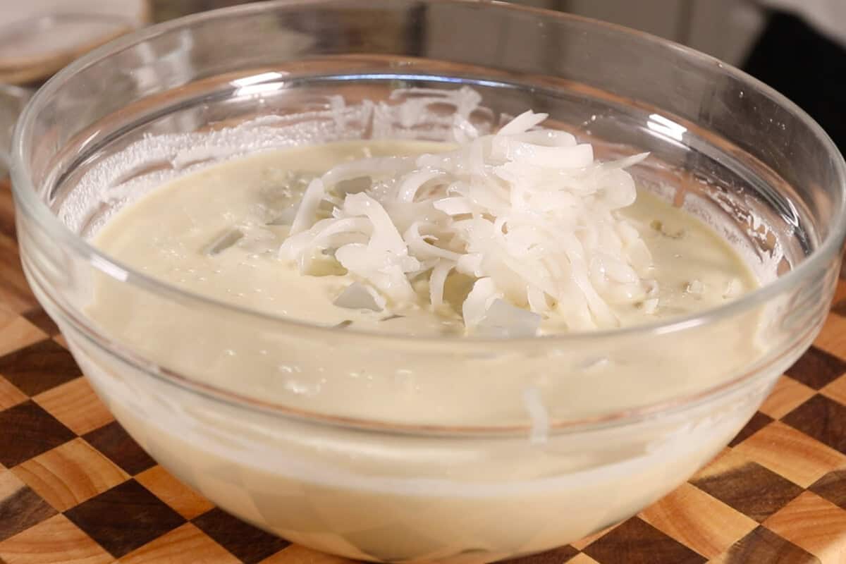 making Filipino Buko Pandan Salad in large glass bowl