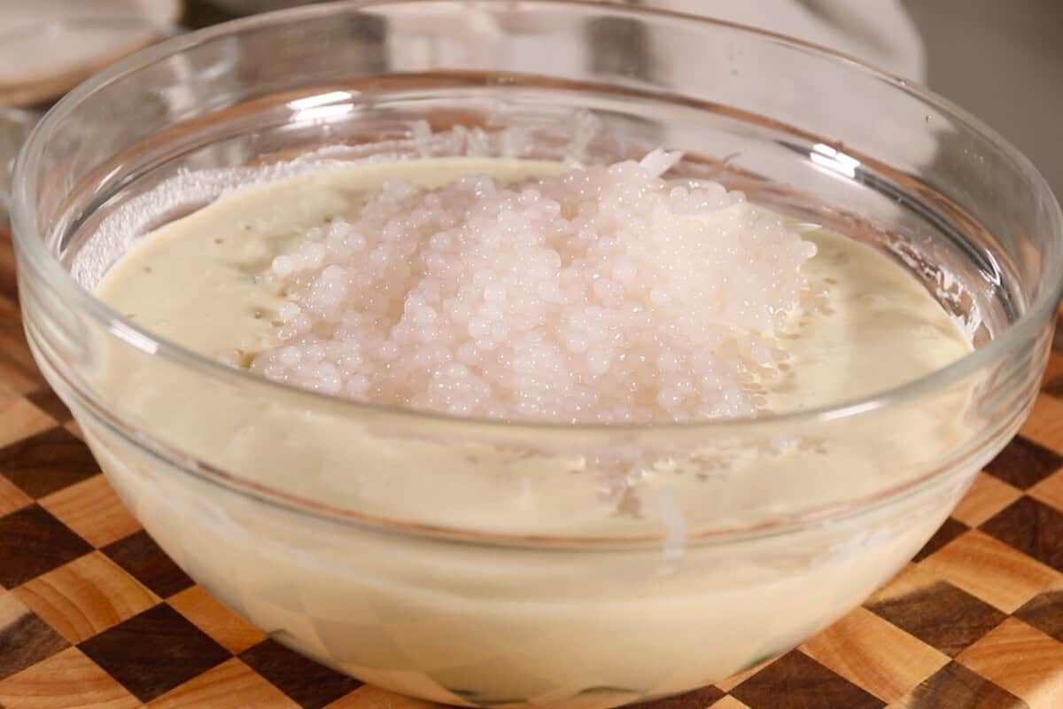 making Filipino Buko Pandan Salad in large glass bowl