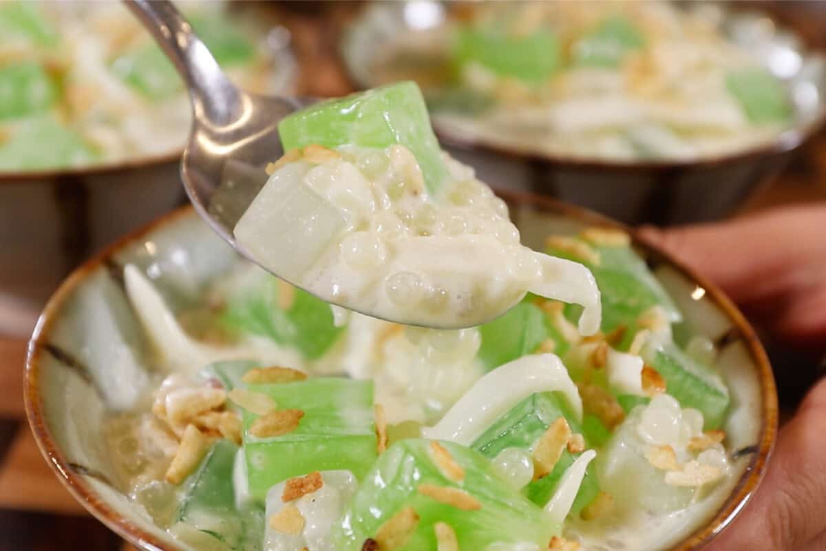 spoon scooping out of a small bowl of Filipino Buko Pandan Salad