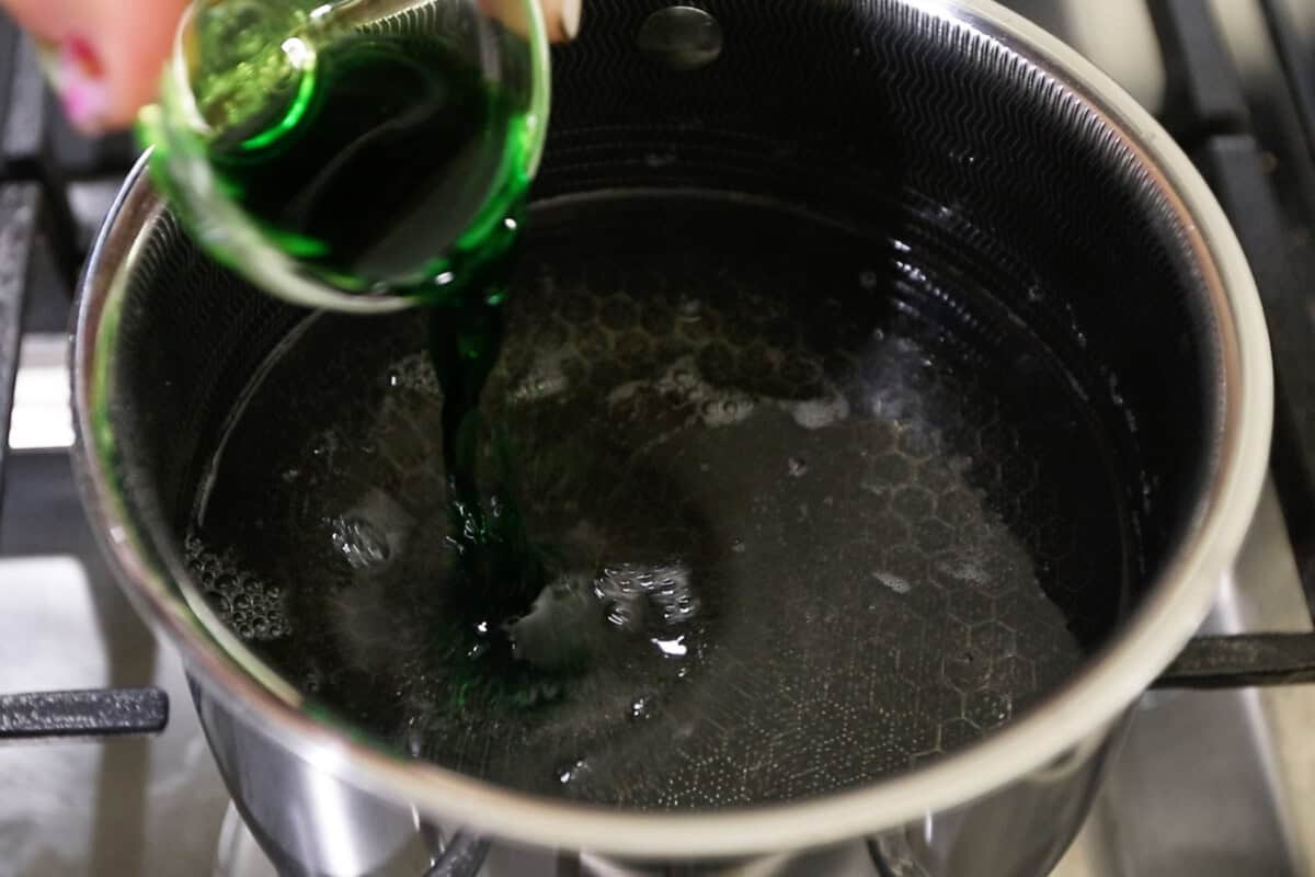 adding pandan extract to small pot for jello