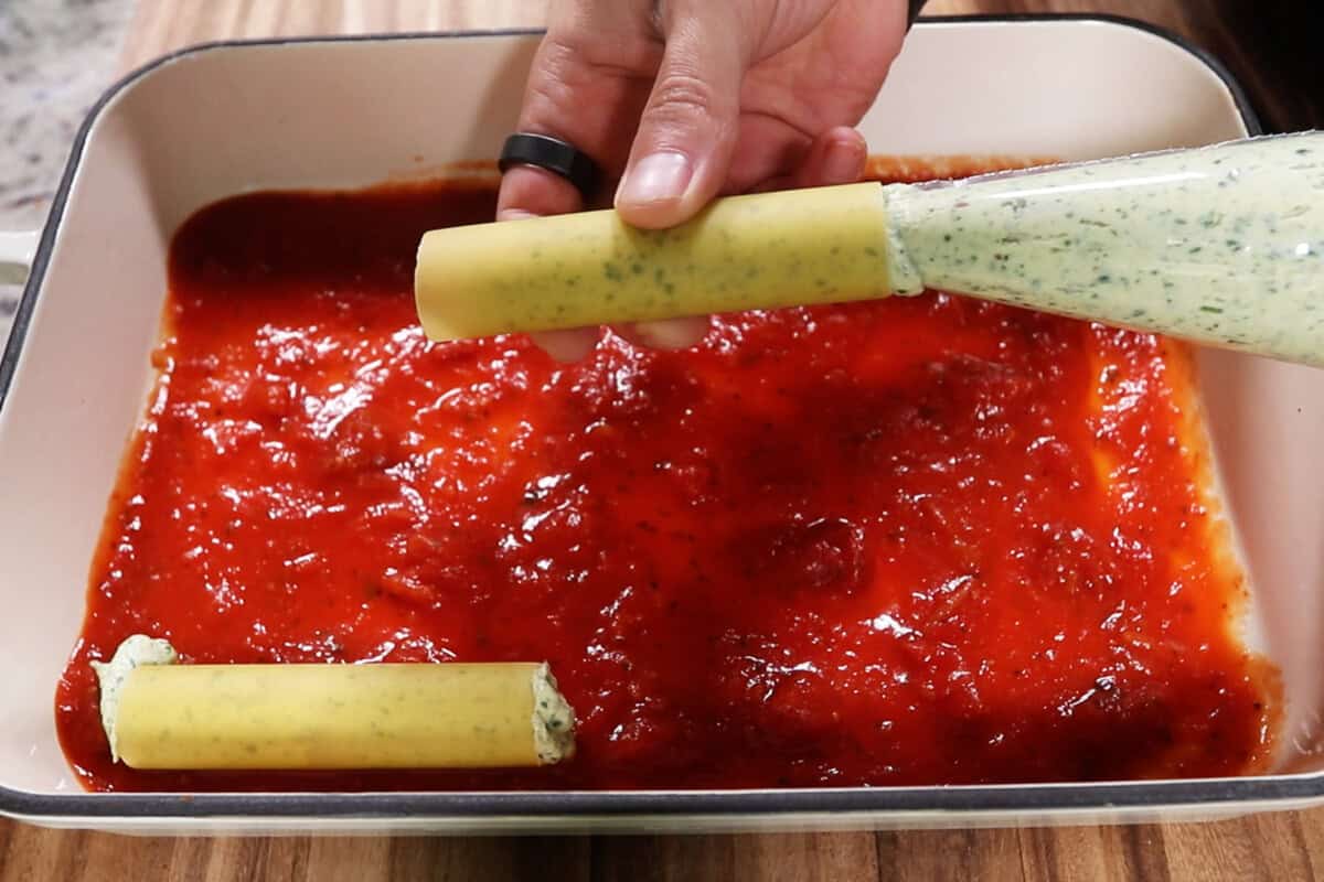 filling manicotti noodles with the tofu ricotta filling