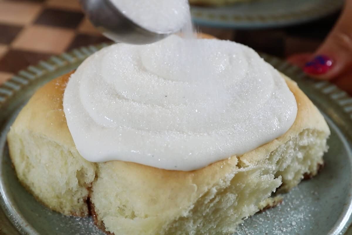 adding sugar on top of the cinnamon roll and custard