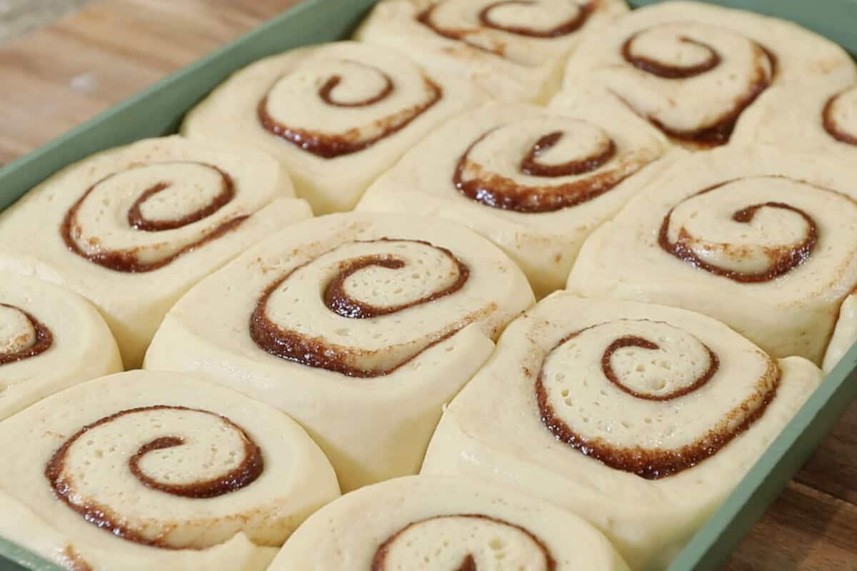 risen cinnamon rolls in baking dish