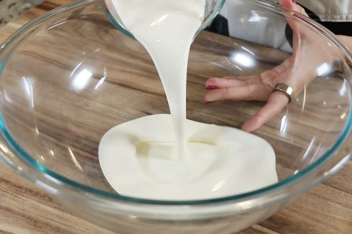 pouring heavy cream into a large bowl