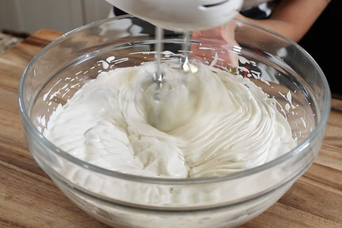 whipping the heavy cream and custard together with a hand mixer