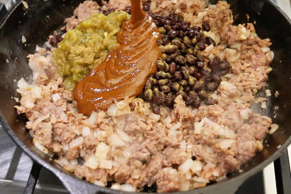 adding sauce to the filling in the skillet