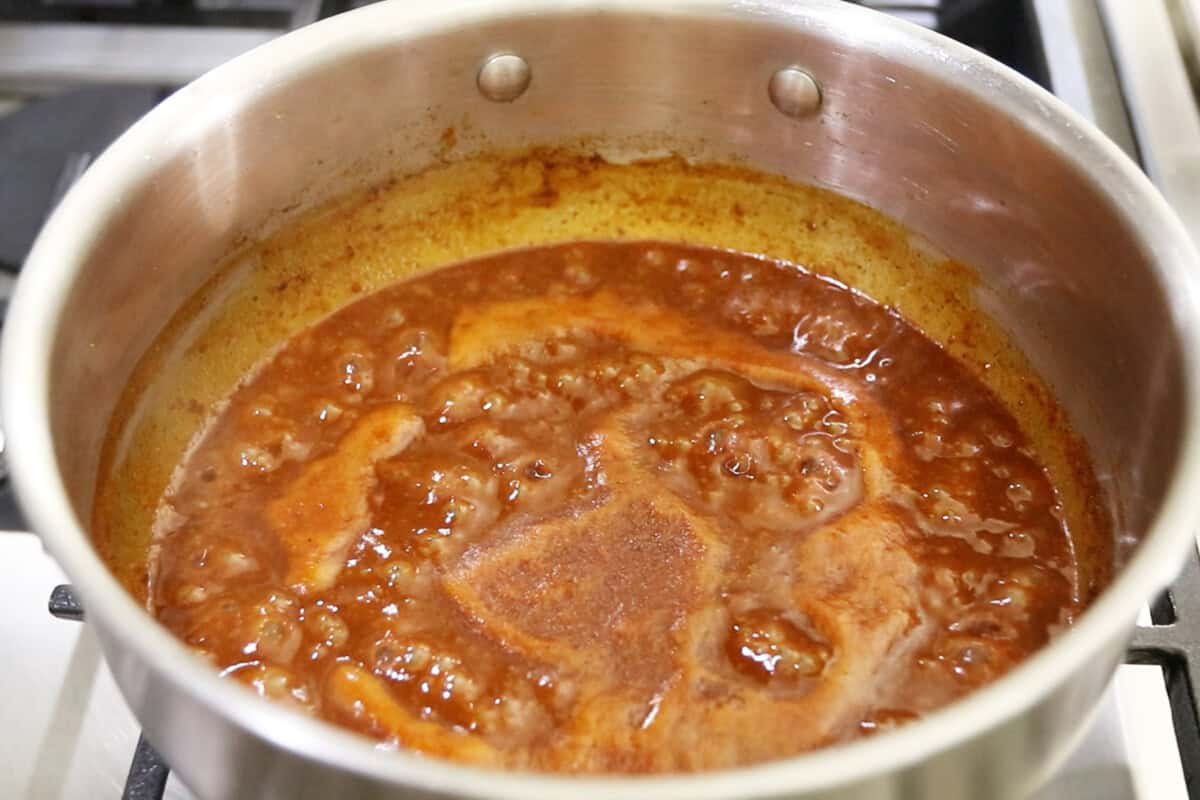 bringing enchilada sauce to a simmer in a pot